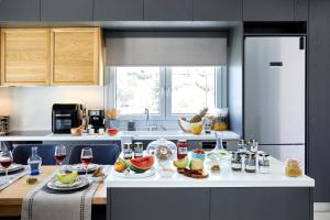 a kitchen with a table with food and glasses of wine at Azura View Foinikas in Finikas