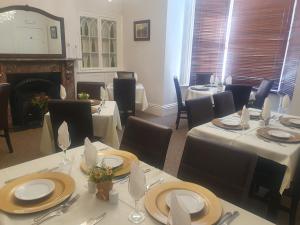 a dining room with tables and chairs and a fireplace at The Shrubbery Hotel in Shepton Mallet