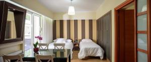 sypialnia z 2 łóżkami, stołem i krzesłami w obiekcie Lume Athens w Atenach