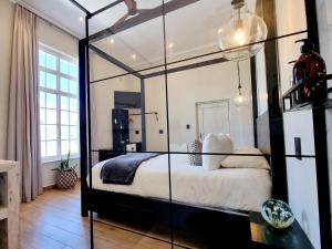 PJURE Wellness Retreat & Spa في مونتاغو: غرفة نوم مع غرفة زجاجية كبيرة مع سرير