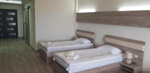 two beds in a room with white sheets and pillows at Cross Resort Hotel in Yerevan