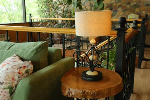 a lamp sitting on a table next to a couch at Madanur Hotel in Karakol