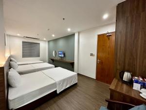 1 dormitorio con 1 cama blanca grande y TV en Hải Âu Hotel, en Xóm Ðé