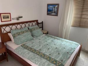 1 dormitorio con 1 cama con sábanas y almohadas verdes en An oasis of relaxation. Feel good - enjoy!, en Santiago del Teide