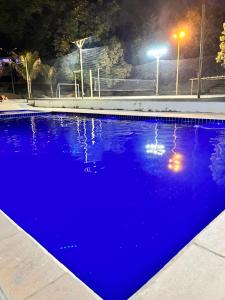 uma piscina azul à noite com luzes em Quinta D’ Aurora em Espírito Santo do Pinhal