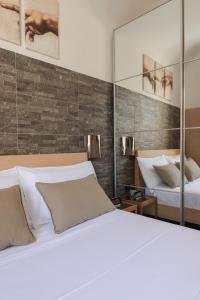 a bedroom with a white bed and a mirror at [Roma Termini] - Suite elegante in Rome