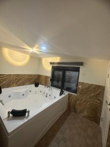 a large white tub in a bathroom with a window at the land of legend luxury in Belek