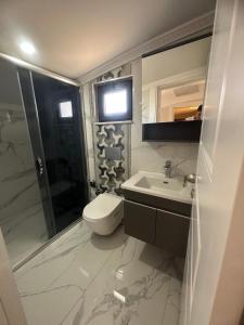 a bathroom with a toilet and a sink and a mirror at the land of legend luxury in Belek