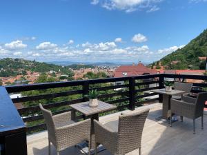 a patio with tables and chairs on a balcony at Casa Cristina in Braşov
