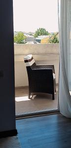 uma cadeira sentada numa varanda com vista para uma janela em Vila Davi em Costinesti