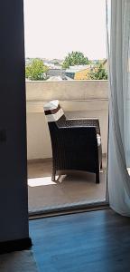 a chair sitting on a balcony looking out a window at Vila Davi in Costinesti