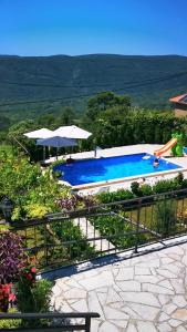 una piscina con sombrillas y una piscina en Vila Nikola en Bratesici
