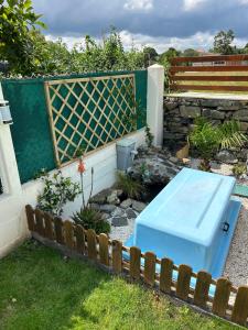 Niebieska ławka w ogrodzie obok płotu w obiekcie Pension San Anton w mieście Melide
