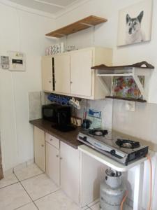 a kitchen with white cabinets and a stove top oven at 17 Clubmed Resort in Hibberdene