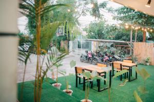 un patio con mesas, sillas, plantas y motocicletas en Greendales - New Extension, en Puerto Princesa City