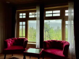 two chairs and a table in front of a window at Orgventure Resorts Skardu in Skardu