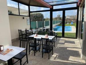 un patio con mesas y sillas y una piscina en Pension San Anton, en Melide
