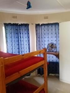 a bedroom with a bunk bed and blue curtains at 17 Clubmed Resort in Hibberdene