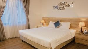 Un dormitorio con una gran cama blanca y una ventana en A25 Hotel - Hoàng Đạo Thuý, en Hanói