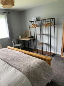 a bedroom with a bed and a desk and a table at 'Kodi's Place' Well appointed 1 bedroom apartment with excellent transport links and free Wi-Fi in Whiteabbey