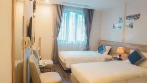 Habitación de hotel con 2 camas y ventana en A25 Hotel - Hoàng Đạo Thuý, en Hanói