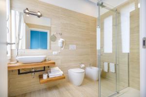 La salle de bains est pourvue d'un lavabo, de toilettes et d'une douche. dans l'établissement Le Suite di Bluemoon, à Cagliari