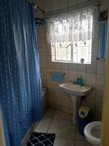 a bathroom with a sink and a blue shower curtain at 17 Clubmed Resort in Hibberdene