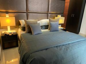 a bedroom with a large bed with two lamps at Platinum 1 in Colombo