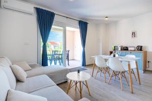 uma sala de estar com um sofá, uma mesa e cadeiras em New 4 star apartment M&A in town Cres em Cres