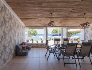 a dining room with a table and chairs and the ocean at Dream on in Kalamaki Heraklion