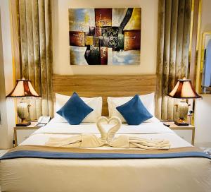 فندق لافيرا الرويبح Lavera Hotel في الرياض: غرفة نوم بسرير مع مصباحين ولوحة