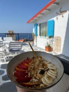 a bowl of food with fruit and bananas on a table at Agape Studios in Neos Marmaras