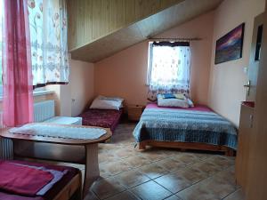 Cette petite chambre comprend 2 lits et une fenêtre. dans l'établissement Jasionka, à Ustrzyki Dolne