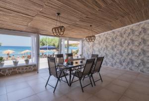 a dining room with a table and chairs and the ocean at Dream on in Kalamaki Heraklion