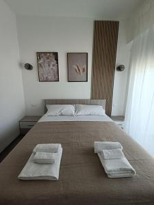 een slaapkamer met een groot bed en 2 handdoeken bij Casa Terka in Conversano