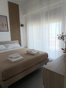 een slaapkamer met een bed met twee handdoeken erop bij Casa Terka in Conversano