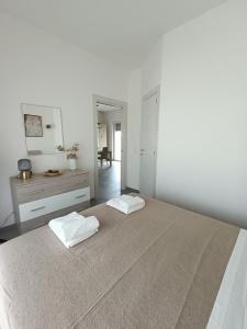 een witte slaapkamer met een groot bed en een spiegel bij Casa Terka in Conversano