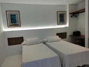 two beds in a room with white walls at Villa Tagoror in Tiagua