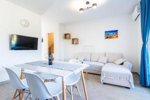 New 4 star apartment M&A in town Cres في كريس: غرفة معيشة مع طاولة وكراسي وأريكة