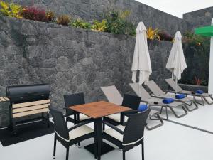 un patio con mesa, sillas y sombrillas en Villa Tagoror, en Tiagua