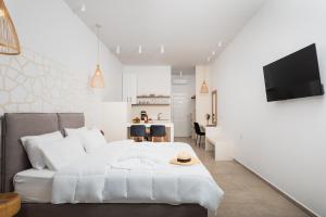 a white bedroom with a bed and a table at Agrilionas Hotel in Marathokampos