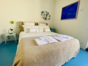 ein Schlafzimmer mit einem großen Bett mit Handtüchern darauf in der Unterkunft Dimora del Sole Luxury and charm apartment in Otranto