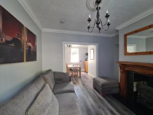ein Wohnzimmer mit einem Sofa und einem Kamin in der Unterkunft Brownlow Townhouse 3 bedroom ideal for contractors and visitors in Lurgan