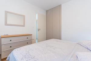 New 4 star apartment M&A in town Cres في كريس: غرفة نوم بيضاء مع سرير وخزانة