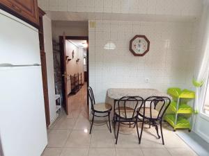 una cucina con tavolo e sedie in una stanza di Cuntis Village L&H a Ferrol