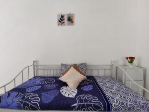 1 dormitorio con 1 cama con colcha azul y blanca en Ambarukmo Green Hill / MA 8 en Yogyakarta