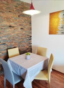 una mesa de comedor con sillas y una planta en Sončni apartma, en Ankaran