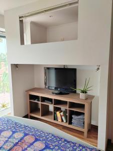 sala de estar con TV en un estante en Sončni apartma, en Ankaran