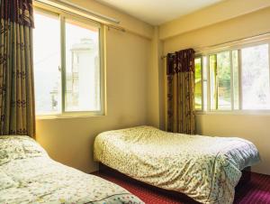 a bedroom with two beds and a window at Season homestay in Kathmandu