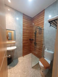 a bathroom with a shower and a toilet and a sink at Little Tokyo in Yogyakarta